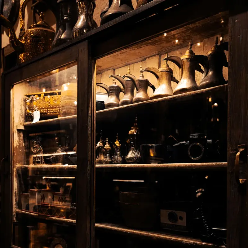 Antique metal collectibles arranged inside a glass display cabinet