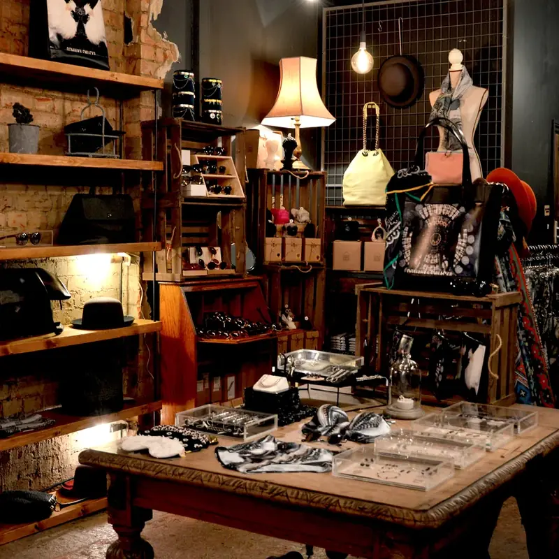 Warm vendor booth display with shelves, accessories, bags, hats, and decor