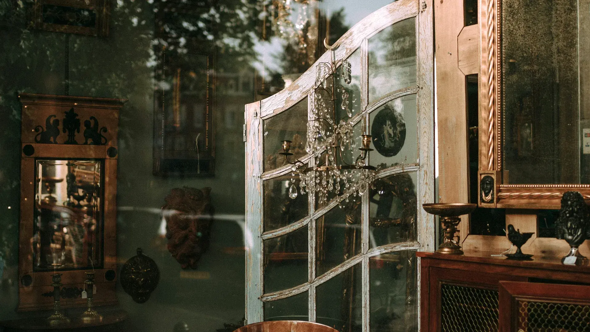 Antique market interior filled with vintage furniture, mirrors, and warm lighting